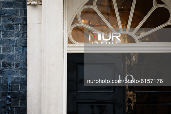 Lights shine behind the door of 10 Downing Street in London, England, on November 4, 2020. 
