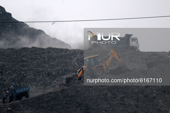 Heavy dust blowing as garbage dumpers moving on Ghazipur landfill amid a layer of smoky haze, as the air quality hit 'severe' levels due to...