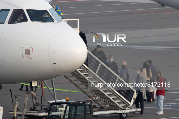 Captain, Pilot and first officer are seen wearing a facemask as passengers are boarding in aircraft at Eindhoven Airport EIN EHEH in the Net...