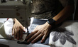 A worker is seen sewing a leaf patterned cloth for a product during fabric making using th...