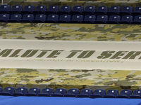 Signs in honor of military personnel are displayed on the seating area of Ford Field during the first half of an NFL football game between t...