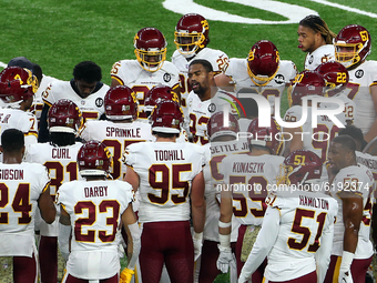Defensive tackle Jonathan Allen (93) of the Washington Football Team talks with teammates before the first half of an NFL football game betw...