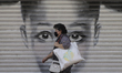 A woman with a mask in front of a curtain in a clothing store in the Zócalo of Mexico City...