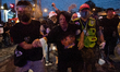A pro-democracy protester is carried by protesters after injured from face off against wit...