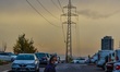 A man wearing a protective face mask walks past a parking lot amid the coronavirus (COVID-...