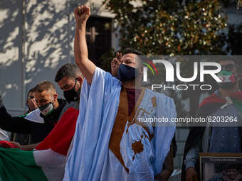 A man wearing face mask a djellaba raises his fist during a demonstration to demand the end of Morocco's occupation in Western Sahara, in su...
