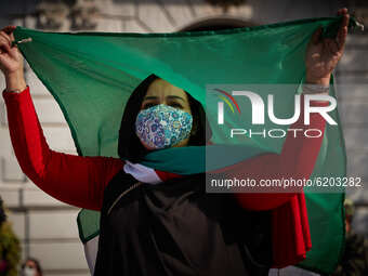 A woman wearing face mask dances under a Sahara flag during a demonstration to demand the end of Morocco's occupation in Western Sahara, in...