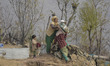 A Kashmiri nomad woman helps a girl carry life stock essentials as winters are approaching...