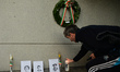 A man lays a candle near images of Bloody Sunday victimes placed outside Croke Park in Dub...