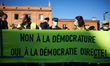 Yellow Vests protesters hold a banner reading 'No to 'Dictatorcy', Yes to direct democracy...