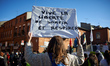 A woman holds a placard reading 'Long live freedom of breathing and getting out'. Thousand...