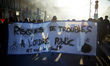 Protesters hold a banner reading 'Risk of disturbing public order, two years in jail'. Tho...
