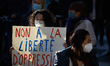 A woman holds a placard reading 'No to the freedom of oppression'. Thousands of protesters...