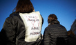 A woman has put a sheet on her back reading 'Future journalist, uncertain future'. Thousan...