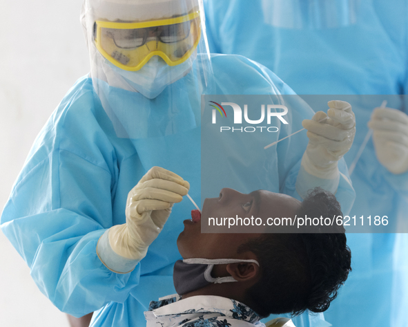 A Sri Lankan Health worker in a protective suit takes a throat swab of a man for a COVID-19 test  at Colombo, Sri Lanka. Monday 23 2020.
Sr...