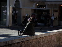 A woman rests at Ermou street.  (