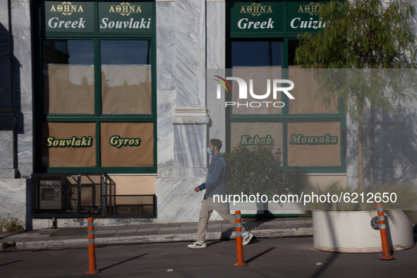 A man passes outside a tradional greek restaurant in Monastiraki district.  