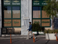 A man passes outside a tradional greek restaurant in Monastiraki district.  (