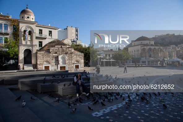 A man eats a sandwich at Monastiraki square.  