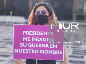 A woman participates in the Day of non-violence against women in Bogota, Colombia, on November 25, 2020 and has a sign that says "President,...