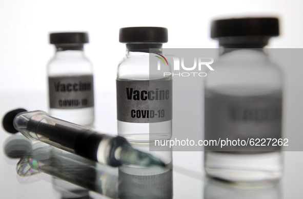 A medical syringe and vials with a sticker reading Vaccine COVID-19 are seen in this creative illustrative photo. More than one hundred fift...