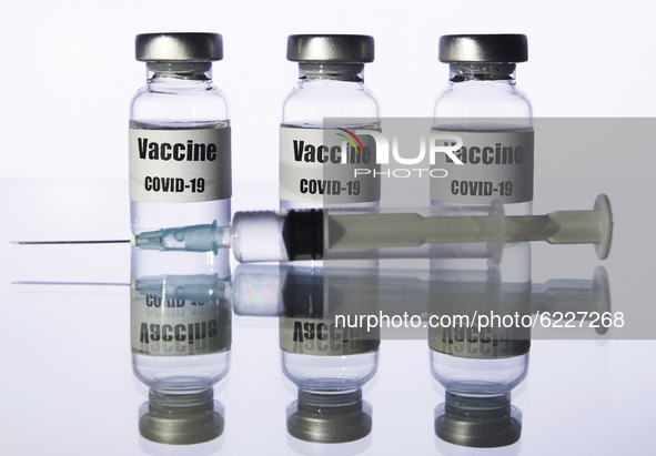 A medical syringe and vials with a sticker reading Vaccine COVID-19 are seen in this creative illustrative photo. More than one hundred fift...