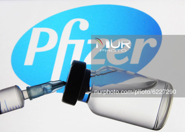 A medical syringe and a vial in front of the Pfizer US pharmaceutical corporation logo are seen in this creative illustrative photo. More th...