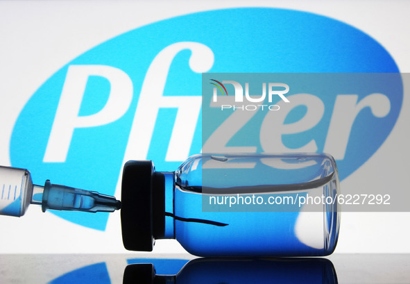 A medical syringe and a vial in front of the Pfizer US pharmaceutical corporation logo are seen in this creative illustrative photo. More th...