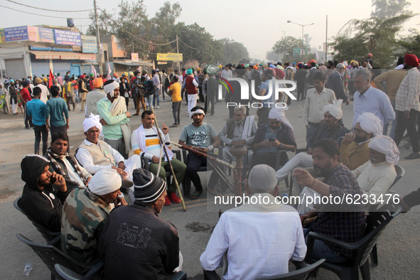 Farmers holding a discussion on the blocked road during a protest against the Centre's new farm laws at Singhu border near Delhi, India on N...