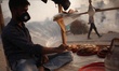 A cake vendor waits for customer inside his polythene wrapped shop as passerby make their...