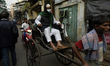 A man sitting on a rickshaw wears a face mask amid coronavirus emergency in Kolkata, India...
