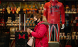 A woman wearing a face mask passes a tourist souvenir store on Oxford Street in London, En...