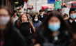 A woman wearing a face mask walks amid shoppers on Regent Street in London, England, on De...