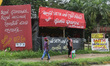 People walk past political banners in the city of Kandy, Sri Lanka.  