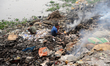 Children playing as garbage burns create toxic smoke on the bank of Buriganga River in Dha...