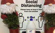Christmas decorations by a bottle of hand sanitizer outside a grocery store during the sec...