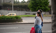 People wait for a bus wearing protective face masks to prevent the spread of the novel Cor...