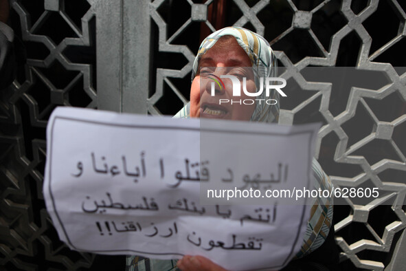 Palestinian relative of orphans and disabled hold banners during a protest against Palestine Bank policy on the closure of the accounts of c...
