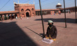 A man wears a mask as a precautionary measure against corona virus inside a mosque on a wi...