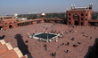 An aerial view showing people around ablution pond inside the courtyard of mosque complex,...