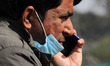 A man wears a protective face mask on his chin, amid the coronavirus disease (COVID-19) ou...
