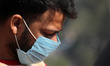A man covers his face with a protective face mask, amid the coronavirus disease (COVID-19)...