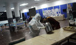 An healthcare worker in personal protective equipment (PPE) assists patients admitted at a...