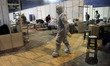 An healthcare worker in personal protective equipment (PPE) assists patients admitted at a...