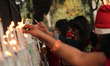People light up candles outside the Sacred Heart Cathedral on the eve of Christmas celebra...