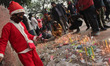 A boy dressed as Santa Claus lights up candles outside the Sacred Heart Cathedral on the e...