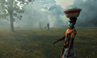 A man wears mask as he walks past a bonfire that set at a park in Dhaka, Bangladesh on Sat...