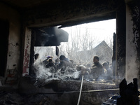 Kashmiri people douse the fire inside a damaged residential house in Kanigam Village of Shopian district, South of Srinagar, Indian Administ...