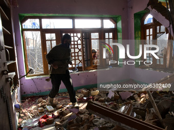 A Kashmiri man  looks for belongings iniside a damaged residential house in Kanigam Village of Shopian district, South of Srinagar, Indian A...