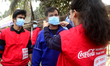Volunteer of Coca Cola International Beverages Private Limited distributing face masks amo...